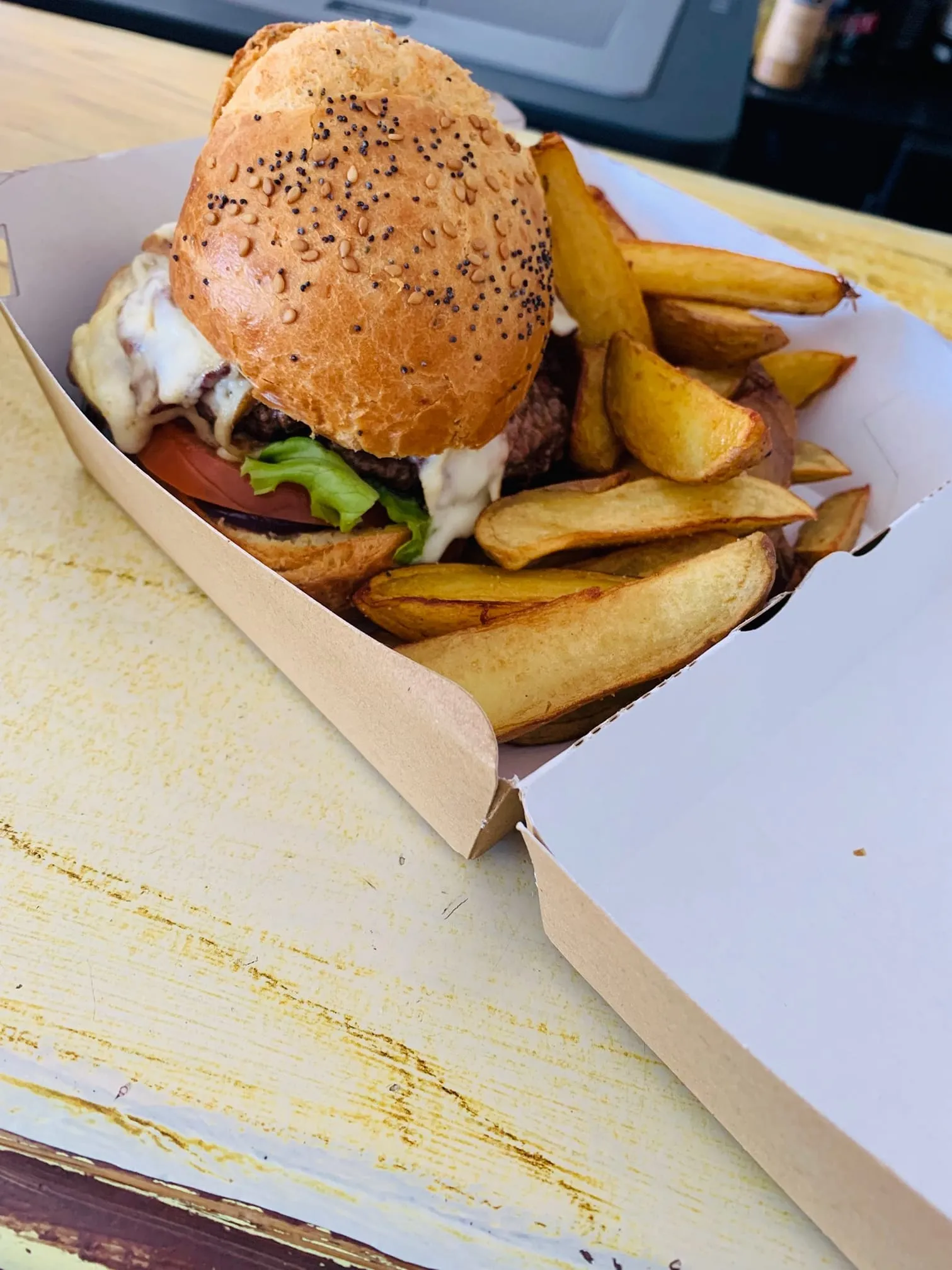 Burger maison et frites servis dans une boîte à emporter