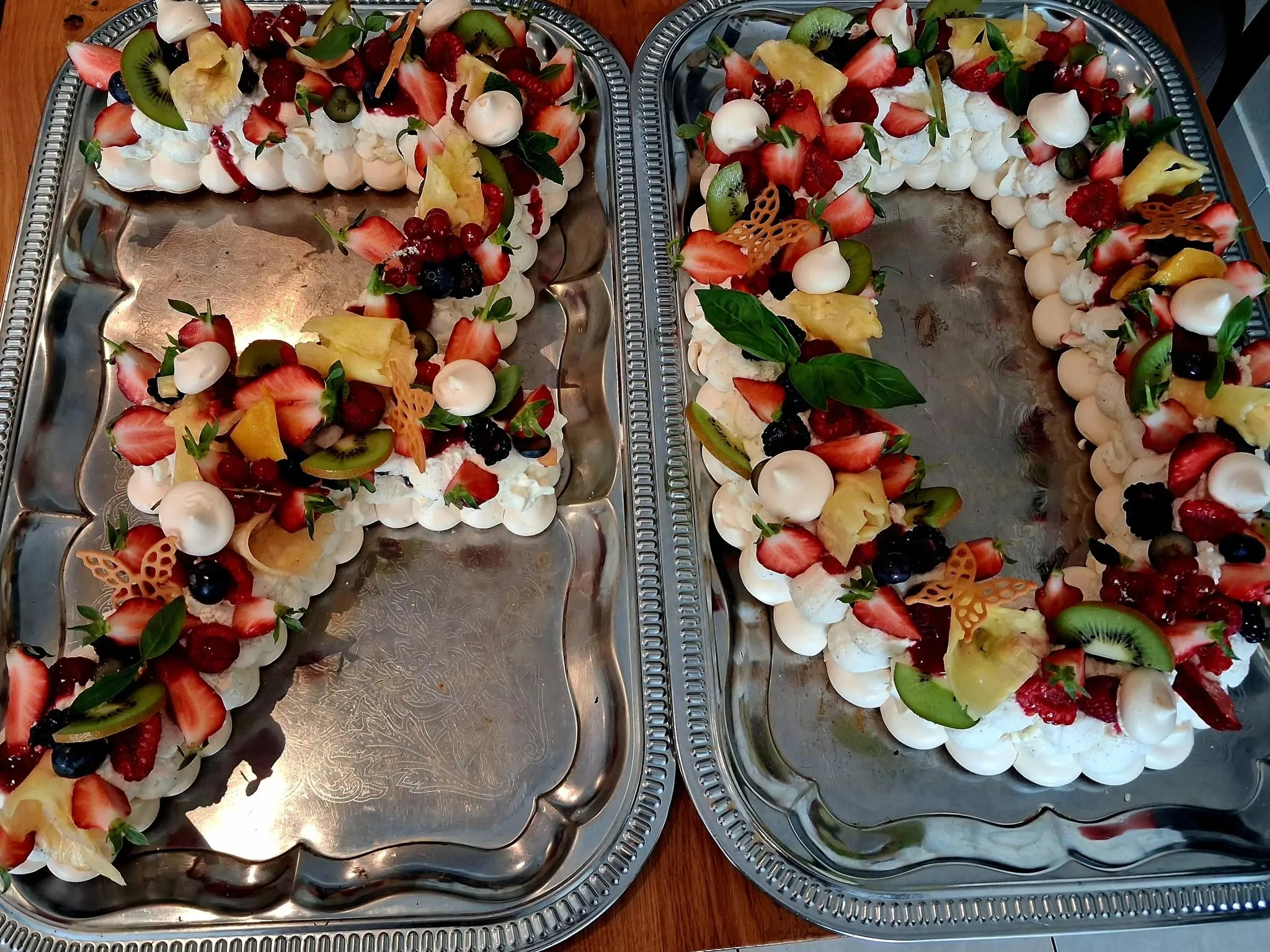 Deux desserts meringués garnis de crème et de fruits frais