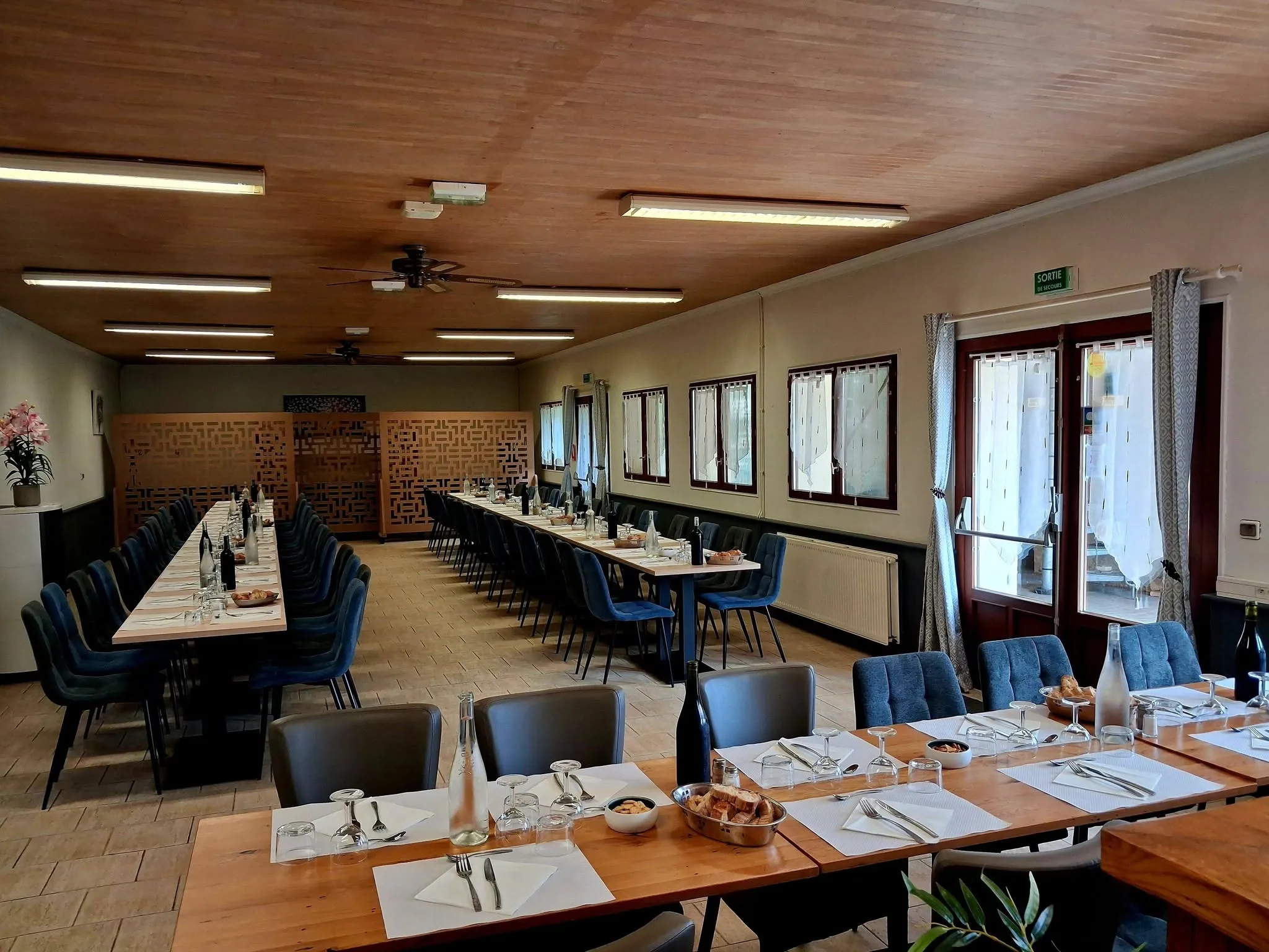 Grande salle du restaurant avec de longues tables dressées