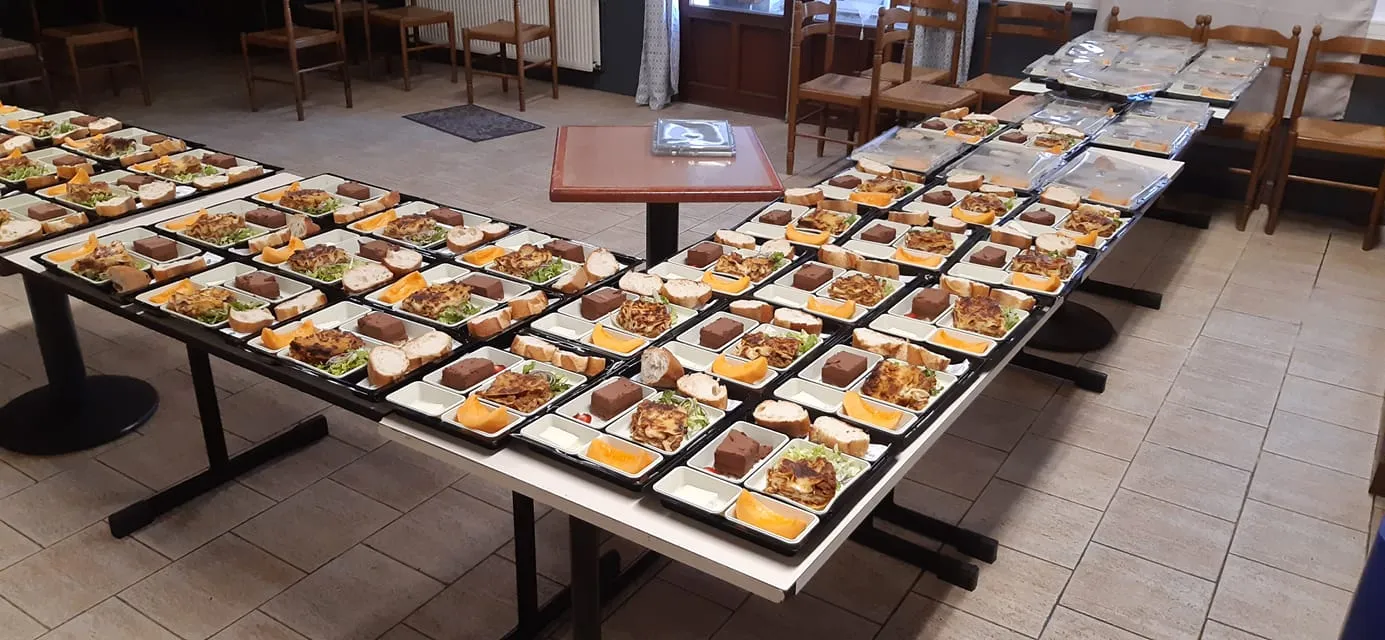 Nombreux plateaux-repas préparés et alignés dans la salle