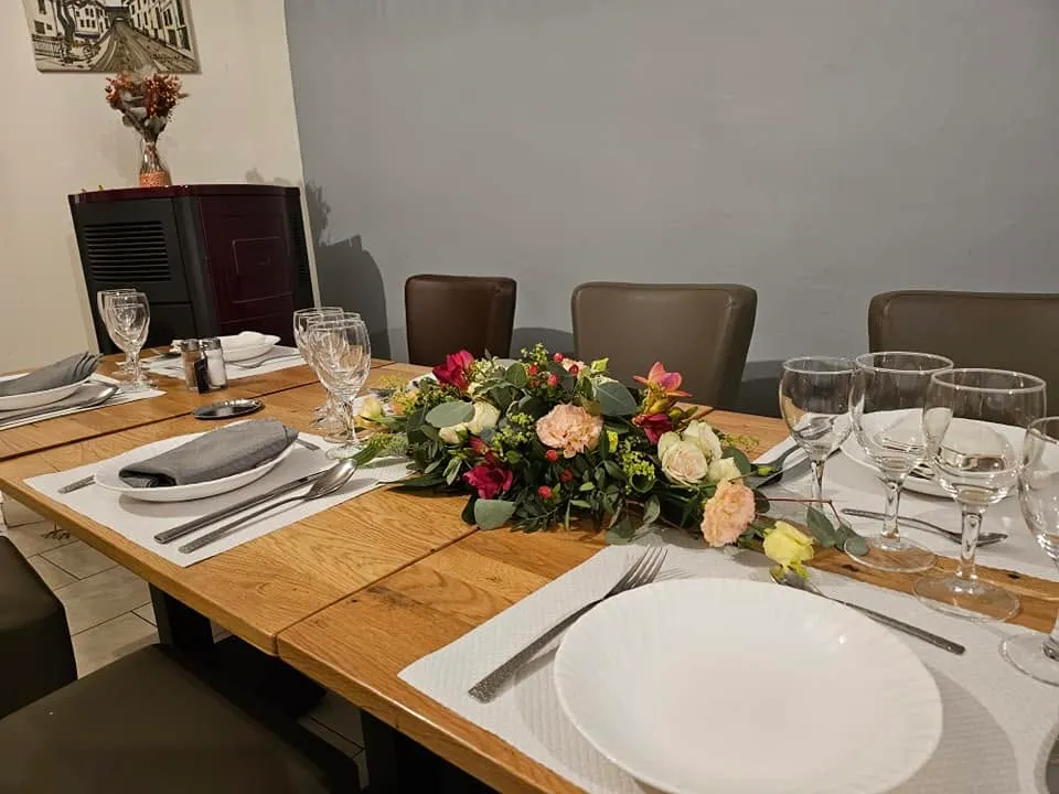 Table dressée avec vaisselle et composition florale dans la salle du restaurant