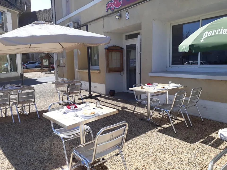 Terrasse extérieure du restaurant avec tables dressées et parasols